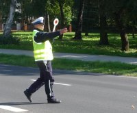 policjant z tarczą sygnałowa daje sygnał do zatrzymania