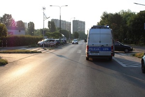 Widok na drogę, z prawej strony radiowóz, z lewej kilka metrów dalej ciemny pojazd osobowy