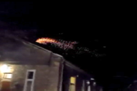 Zdjęcie kolorowe wykonane w godzinach nocnych. Widać jak z komina budynku wielorodzinnego wydobywają się iskry.