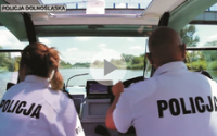 dwóch policjantów na łódce w białych polówkach