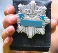 policyjna odznaka trzymana w ręce