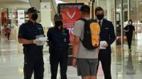 policjanci oraz pracownicy kontrolujący noszenie maseczki w galerii handlowej