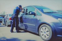 policjant zagląda przez szybę do auta