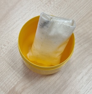 substancja umieszczona w folii a następnie w żółtej misce znajdującej się na stole