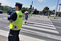 policjant w kamizelce odblaskowej przed przejściem dla pieszych