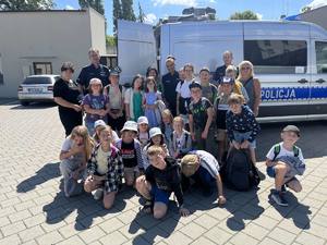 na zdjęci są policjanci z KPP w Gnieźnie oraz dzieci z półkolonii ze środowiskowym programem profilaktycznym organizowanym przez Stowarzyszenie Młodych Wielkopolan