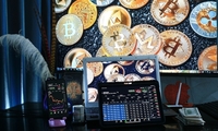 kolorowy plakat, w tle laptop i monety ze znakiem bitcoin