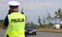 policjant w białej czapce i kamizelce na drodze