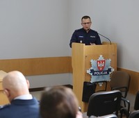 policjant w średnim wieku przed mównicą