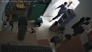 Zdjęcie kolorowe, widok na sklep z góry z kamery sklepowej. Widać mężczyznę około 30 lat wchodzącego do pomieszczenia.