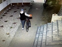 Zdjęcie korowe z monitoringu. Mężczyzna prowadzi rower.