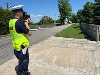 policjant mierzący prędkość pojazdów na drodze