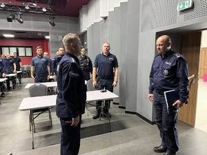 Policjant składa meldunek komendantowi.