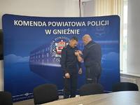 Komendant przypina odznakę policjantowi