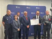Policjant i osoby dorosłe na tle baneru.