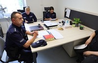 Policjant siedzi przy biurku.