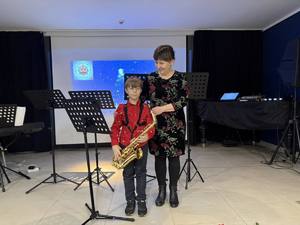 Chłopiec wraz z nauczycielka podczas występu muzycznego.